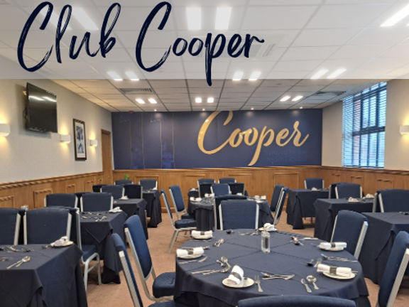 Bright room with small round tables with blue linen and blue banqueting chairs. Text reads Club Cooper.