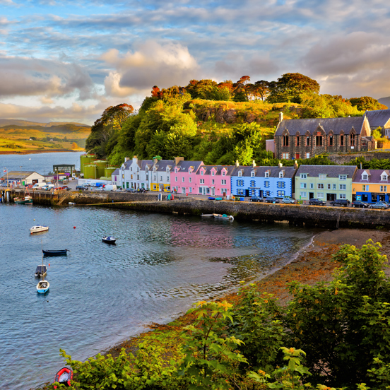 Row of colourful houses on the shoreline, with small boats in the water