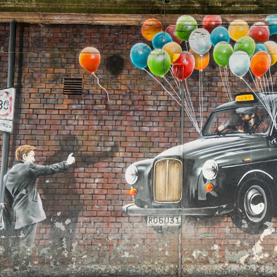 Mural of a man hailing a floating black cab, with colourful balloons tied to its wingmirrors