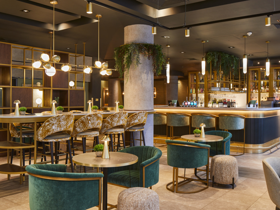 Hotel bar and restaurant area with gold and green accents.