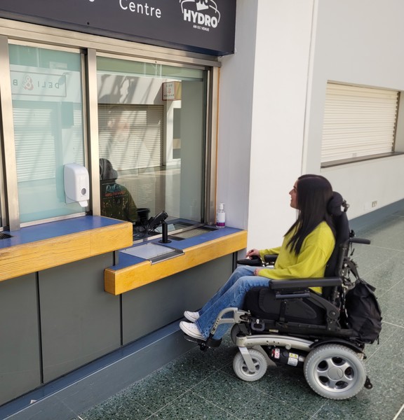 Wheelchair user in front of information desk at the Scottish Event Campus