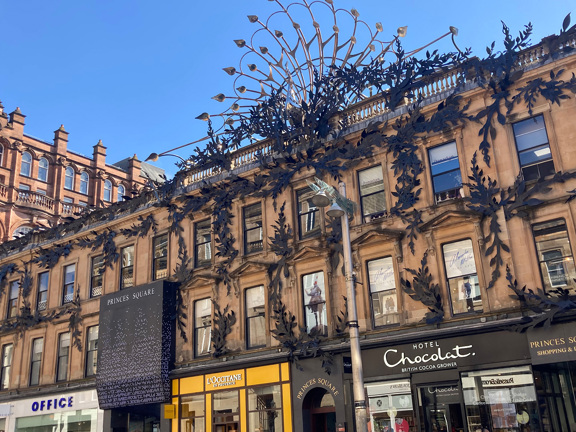 Shopping centre in Glasgow called Princes Square with ornate iron work across the building.