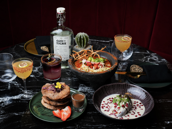 Several food dishes laid on a black and white marble table.