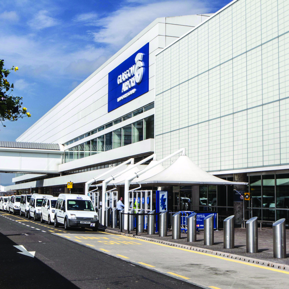 Airport exterior with access road and taxis in front