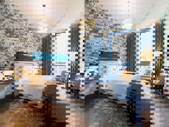 Extra large, bright and light hotel bedroom at Radisson Blu with kingsize bed, sofa and floor to ceiling windows.