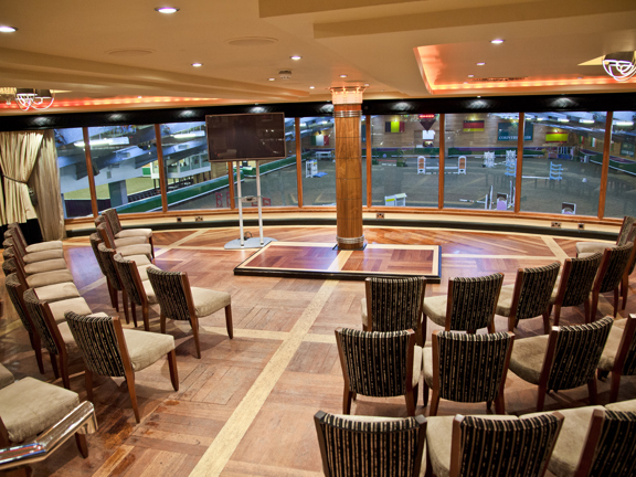 Venue space with floor to ceiling windows, chairs set up in a semi circle