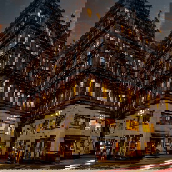 Exterior of a red sandstone hotel building. 