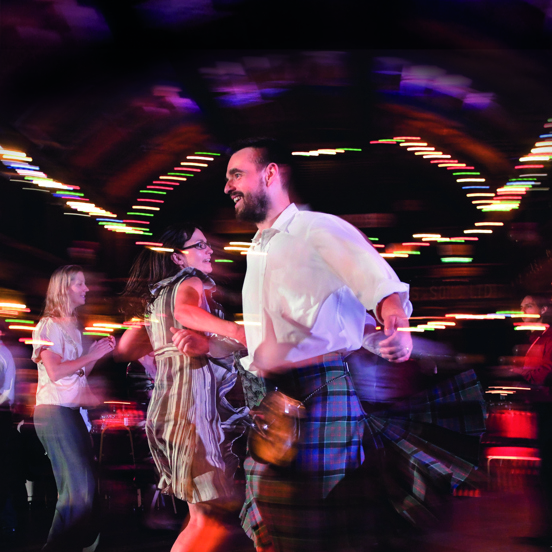 a man and woman spinning with liked arms, ceilidh dancing