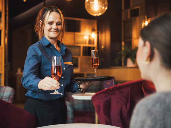 waitress serving glass of wine