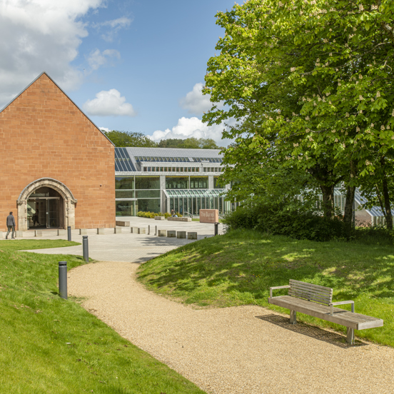 Person entering the glass and brick structure of The Burrell Collection