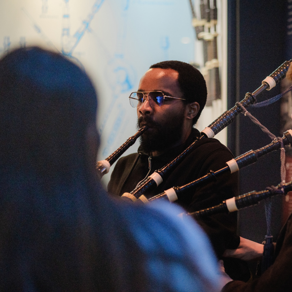 Bagpiper demonstrating traditional Scottish music at The National Piping Centre in Glasgow