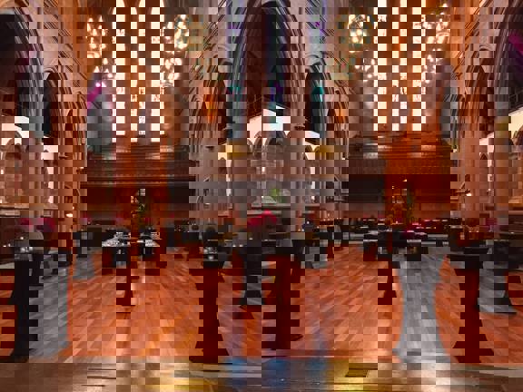 Gothic style Grand Hall at The Barony set up for a drinks reception with occasional tables covered in black cloths.