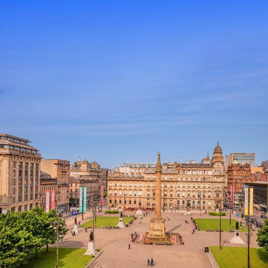 sunny view of George Square with a 24m column in the centre with a statue of Sir Walter Scott
