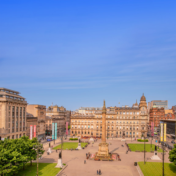 sunny view of George Square with a 24m column in the centre with a statue of Sir Walter Scott
