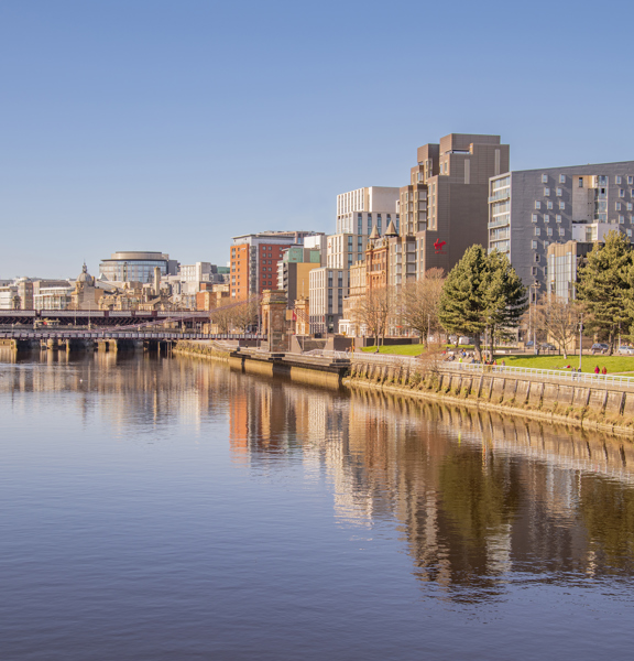 Sunny view of the River Clyde, with modern buildings on the bank, including the Virgin hotel