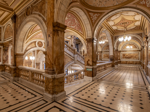 Interior view of the City Chambers marble staircases. The image showcases the ornate marbled staircase and arches with tiled floor