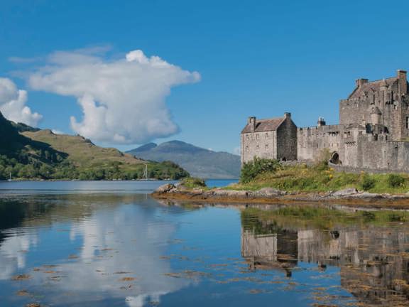 Highlands Eilean Donan Castle siting on a rocky peninsula on a Loch in Scotland
