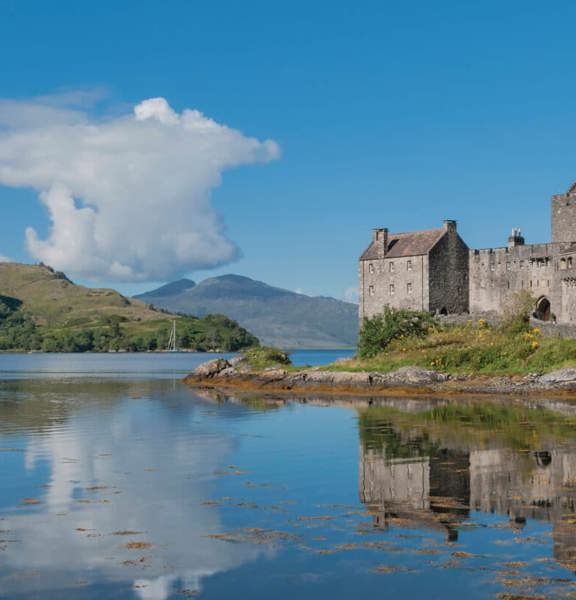 Highlands Eilean Donan Castle siting on a rocky peninsula on a Loch in Scotland