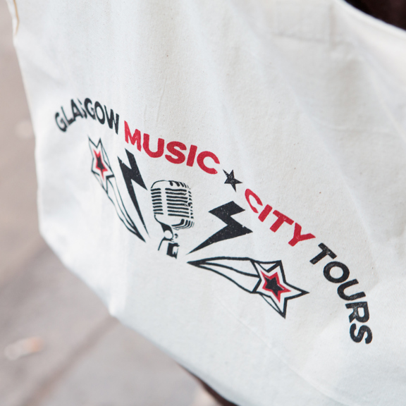 Close-up of a Glasgow Music City Tours tote bag with microphone and star graphic