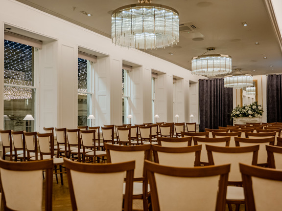 Large event space with large windows looking out to square with fairy lights. 