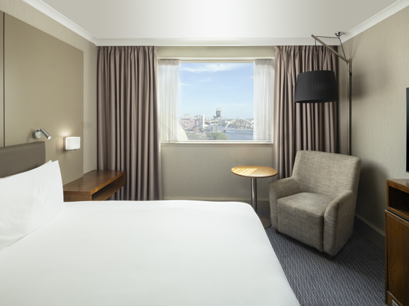 Room with double bed and chair. View across river from window