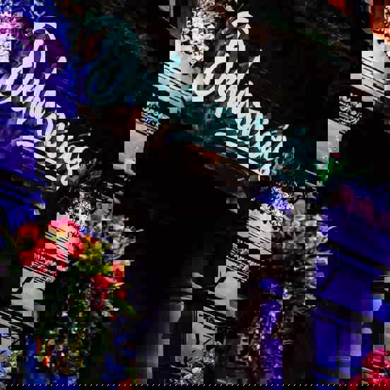 Lit sign above door reading Delmonica's