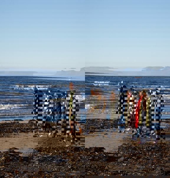 Group of people walking along the beach.