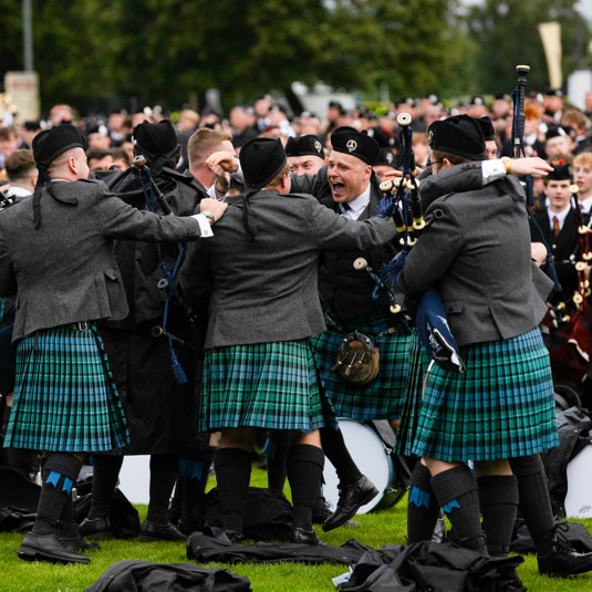 Celebrations of the pipe band winners all jumping about