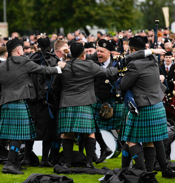 Celebrations of the pipe band winners all jumping about