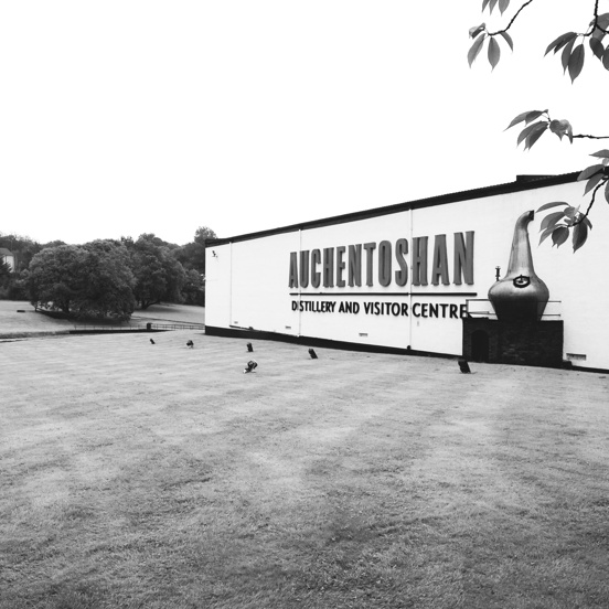 Large white building with a sign that reads Auchentoshan Distillery and Visitor Centre