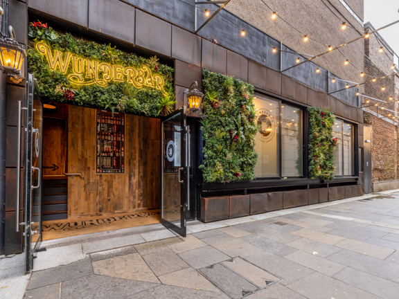 Entrance to Wunderbar Glasgow with illuminated sign above the door.