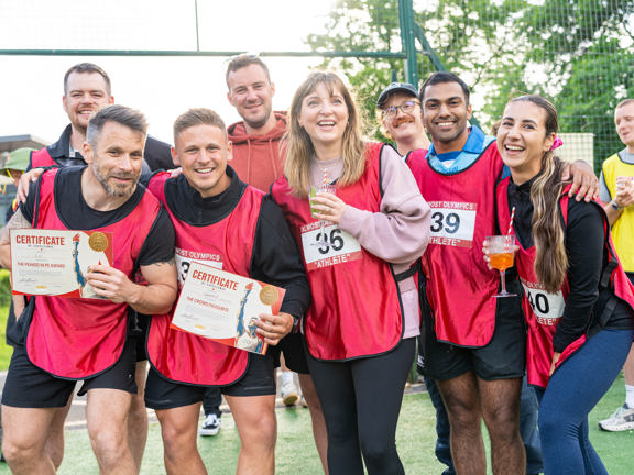 Group of team mates following a game holding a certificate