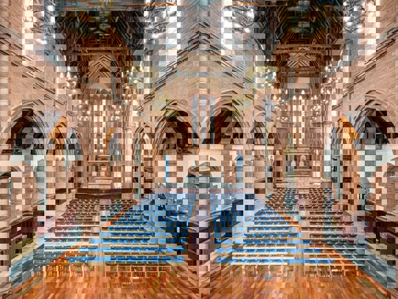 The gothic style grand Hall at The Barony set for a conference with rows of blue seats. 