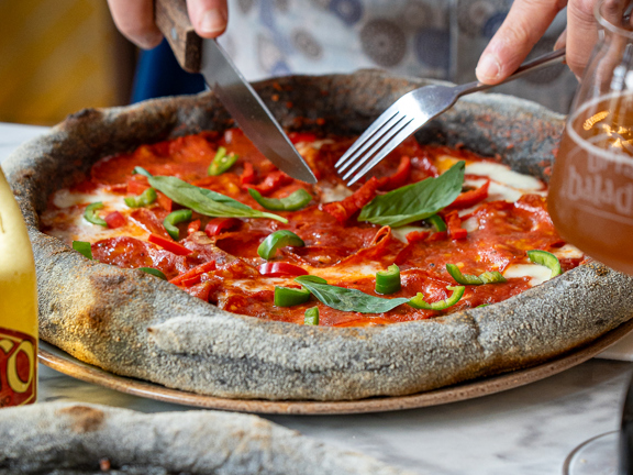 Person tucking into a pizza