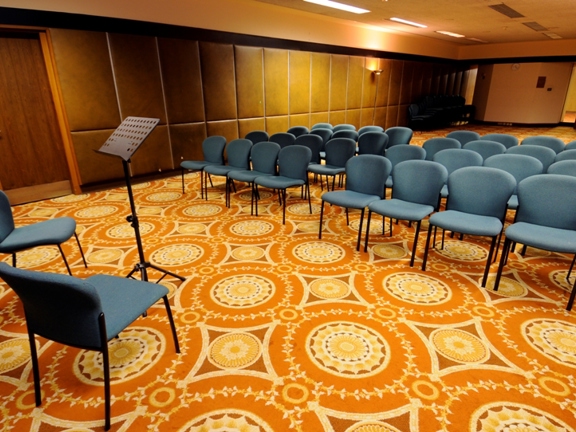 Room with orange carpet and turquoise chairs 