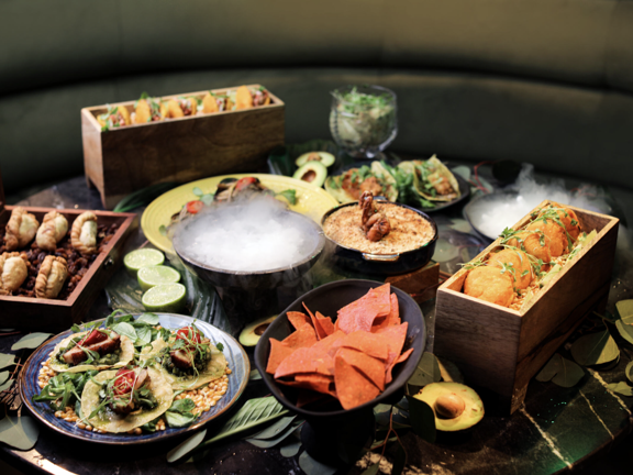 Table laid with several food dishes. 