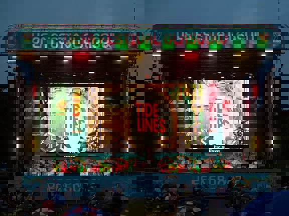 Tide Lines band performs onstage at dusk, the sign reads UEFA Festival Glasgow.