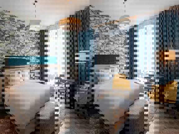 Bright and light hotel bedroom at Radisson Blu with kingsize bed and floor to ceiling windows.