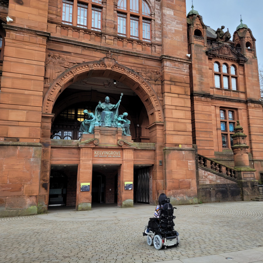 Person in wheelchair in front of Kelvingrove Art Gallery and Museum