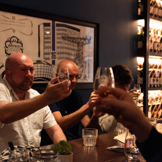 Group of people in a pub setting on a whisky tasting. 