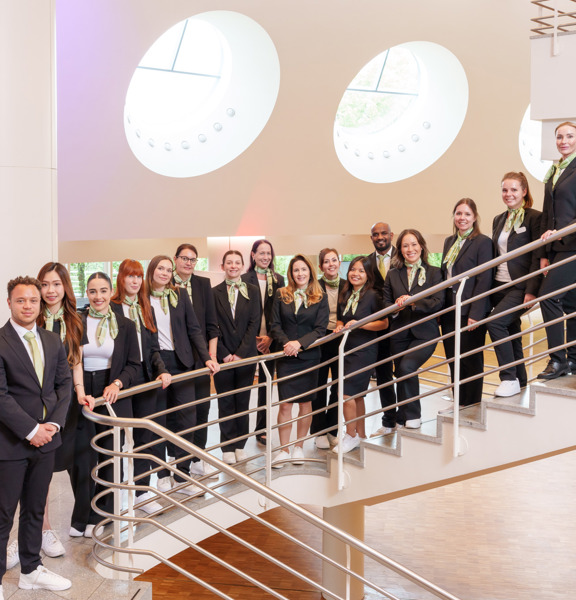 Professionally dressed people standing in a row down a flight of stairs