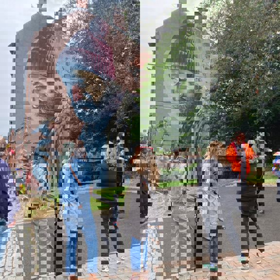 People on a walking tour of Glasgow looking at street art mural