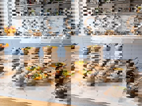 Marble topped table laid with bowls of food and dips.