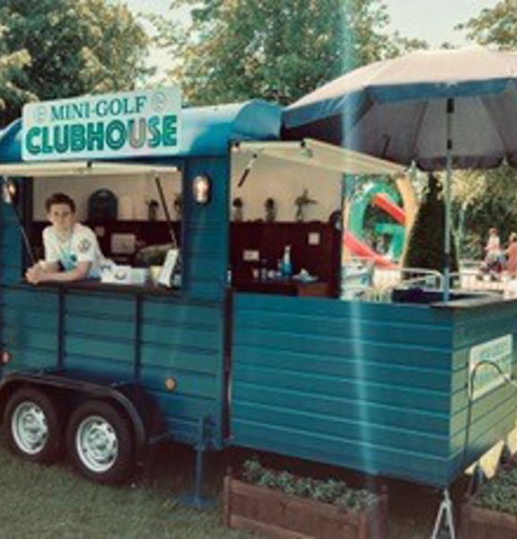 Mobile trailer designed as a mini golf clubhouse on a sunny day in park