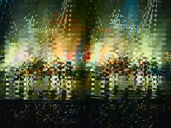 A band perform on stage, in front of a Celtic Connections sign.