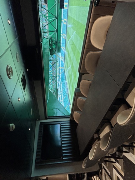 Room with table and chairs overlooking Celtic Park stadium