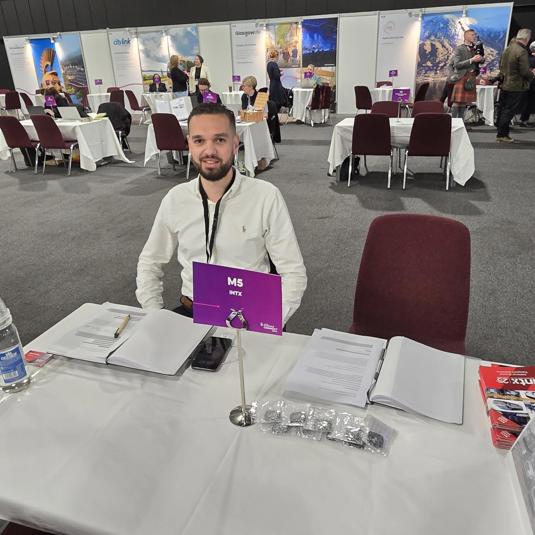 Person sitting at table awaiting business appointments at an event called VisitScotland Connect