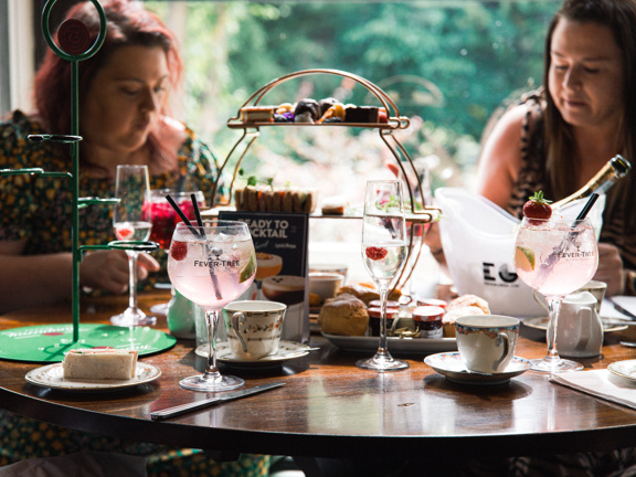 Two women enjoying afternoon tea treats and drinks