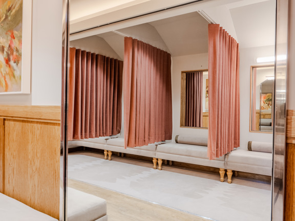 Parlour with changing rooms, velvet curtains, soft seating and large mirrors. 
